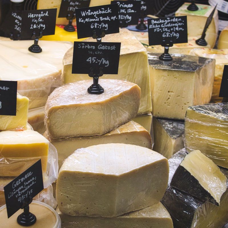 A variety of cheeses are displayed in a display case