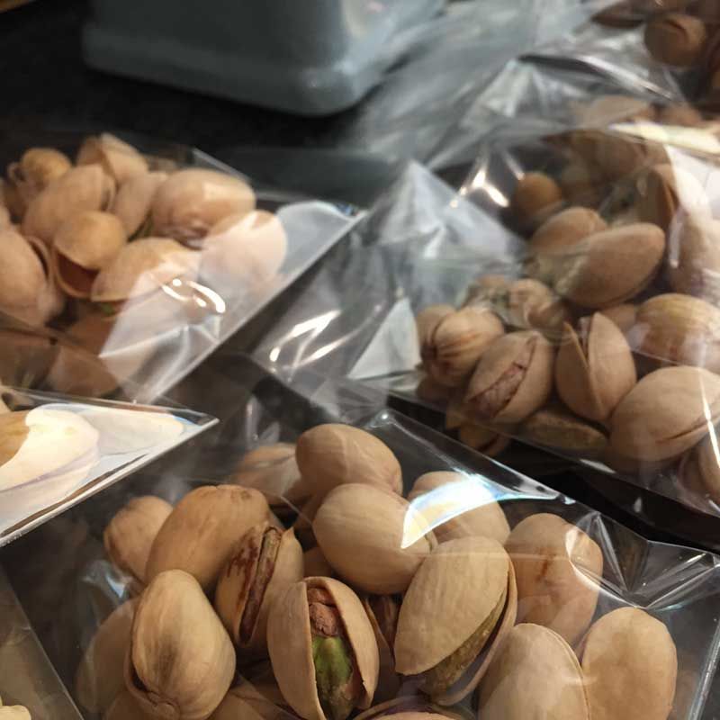 A bunch of pistachios in plastic bags on a table