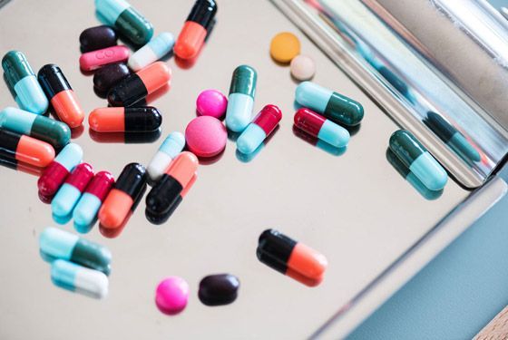 A tray of colorful pills and capsules on a table.