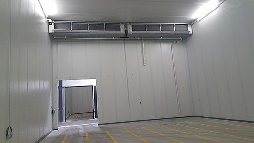 A large empty warehouse with a sliding door leading into it.