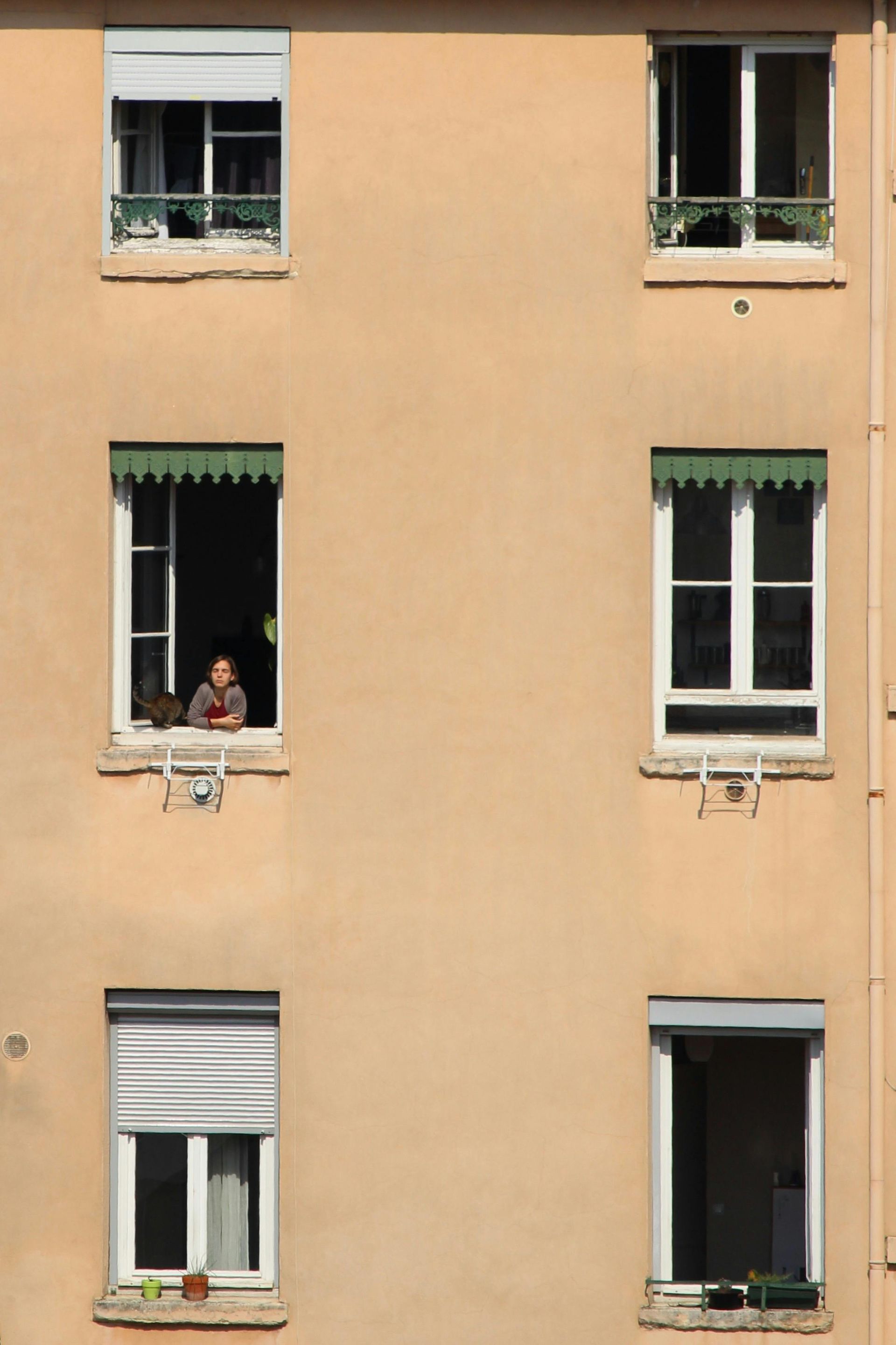 A man is looking out of a window of a building
