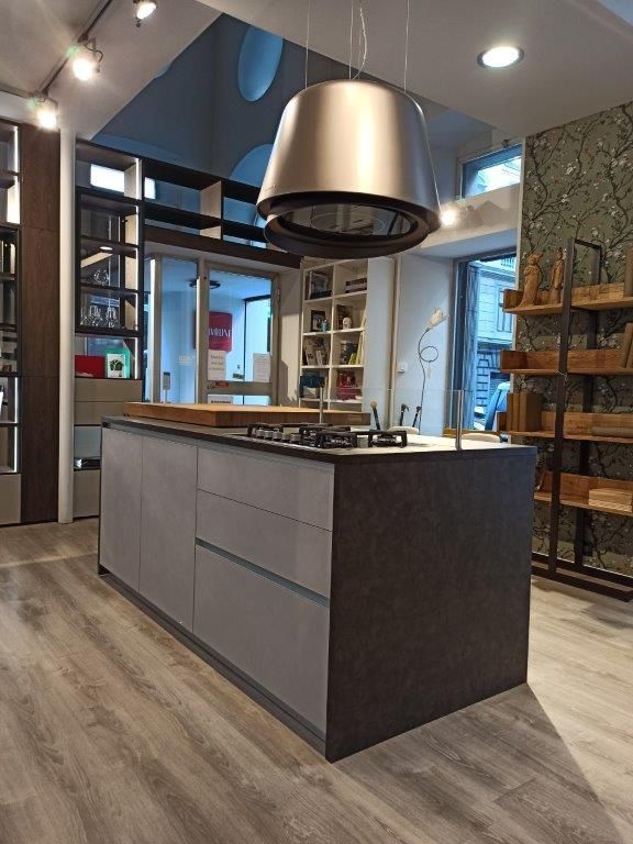 Cucina moderna con isola centrale, cappa aspirante in acciaio inox, mobili grigio chiaro e pavimento in legno.