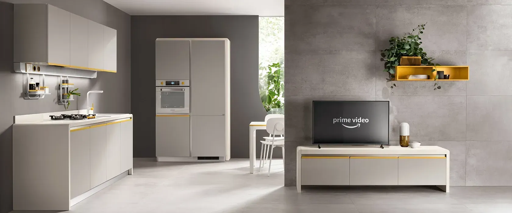 Cucina e zona giorno moderne e bianche con frigorifero a incasso, divano e piante in vaso.