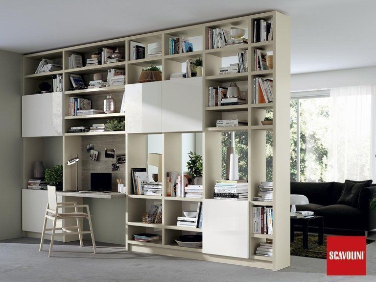 Soggiorno moderno con una parete attrezzata con libreria a muro e una zona scrivania vicino a una grande finestra.