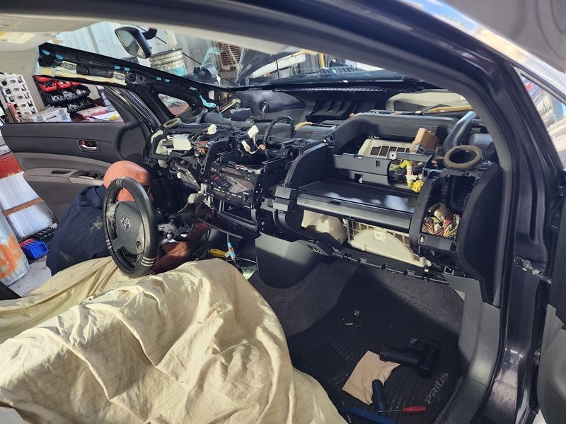 Car interior stripped for repair, showing exposed dashboard, steering wheel, and wiring. | Polar Bear Auto Care