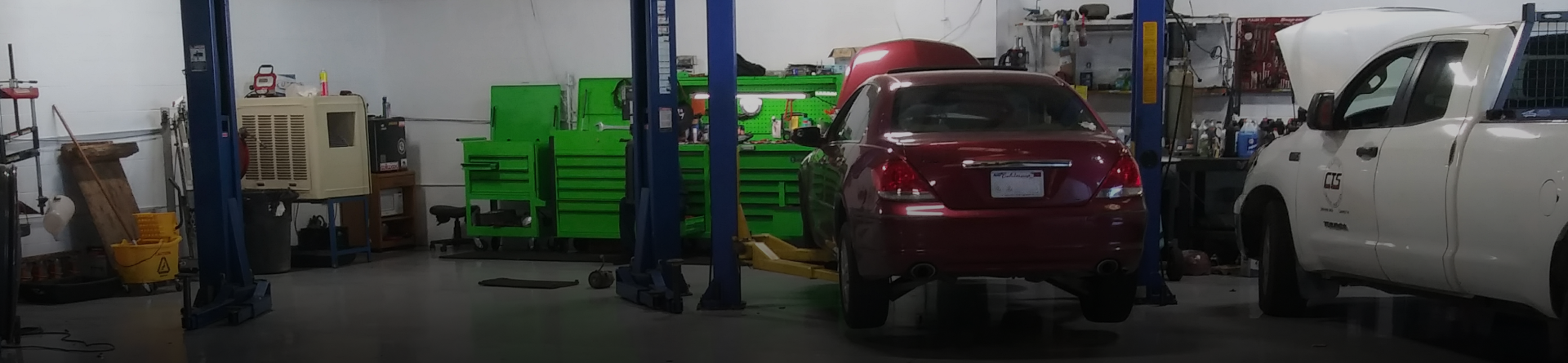 Auto repair shop with a red SUV centered, a white car on the right, and lifts | Polar Bear Auto Care