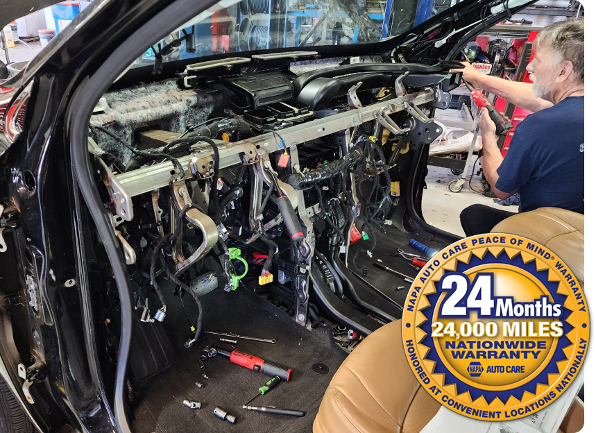 Damaged car interior with exposed wiring; mechanic working beside it, 24-month inspection sticker | Polar Bear Auto Care