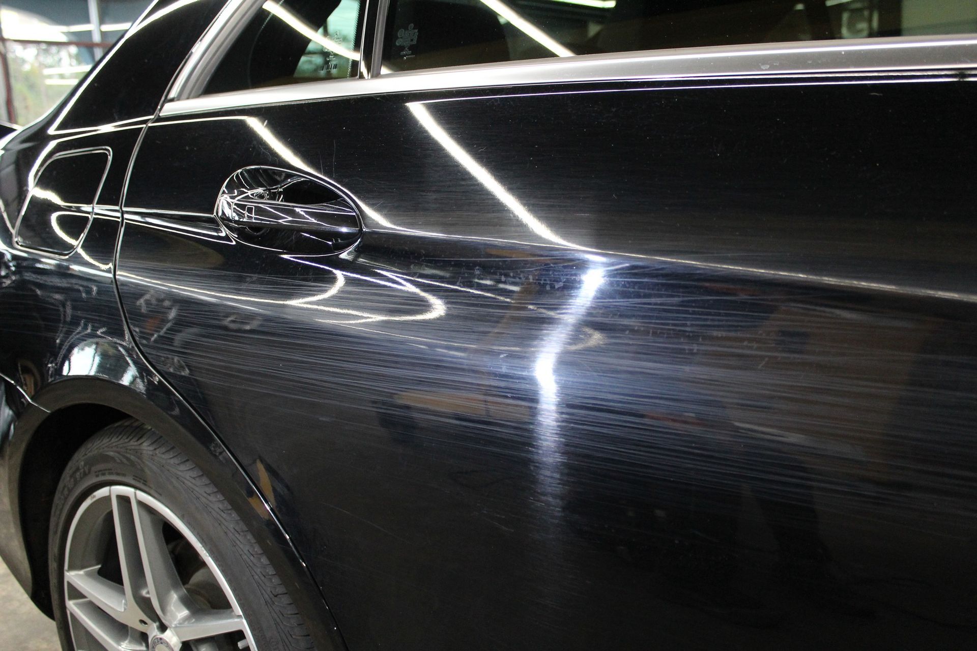 A close up of a black car with a white stripe on the side.