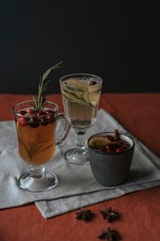Tall cocktail with red chili rim and lime garnish, on a red cloth.