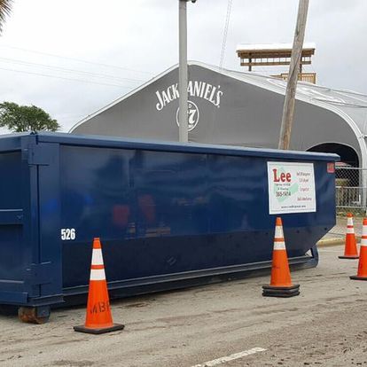 A blue dumpster with a sign that says lee on it