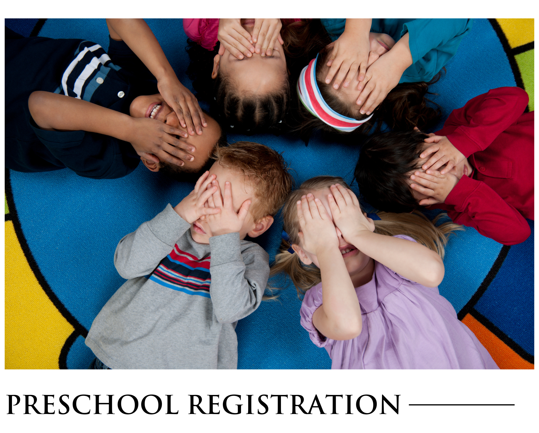 A group of children laying in a circle covering their eyes with their hands