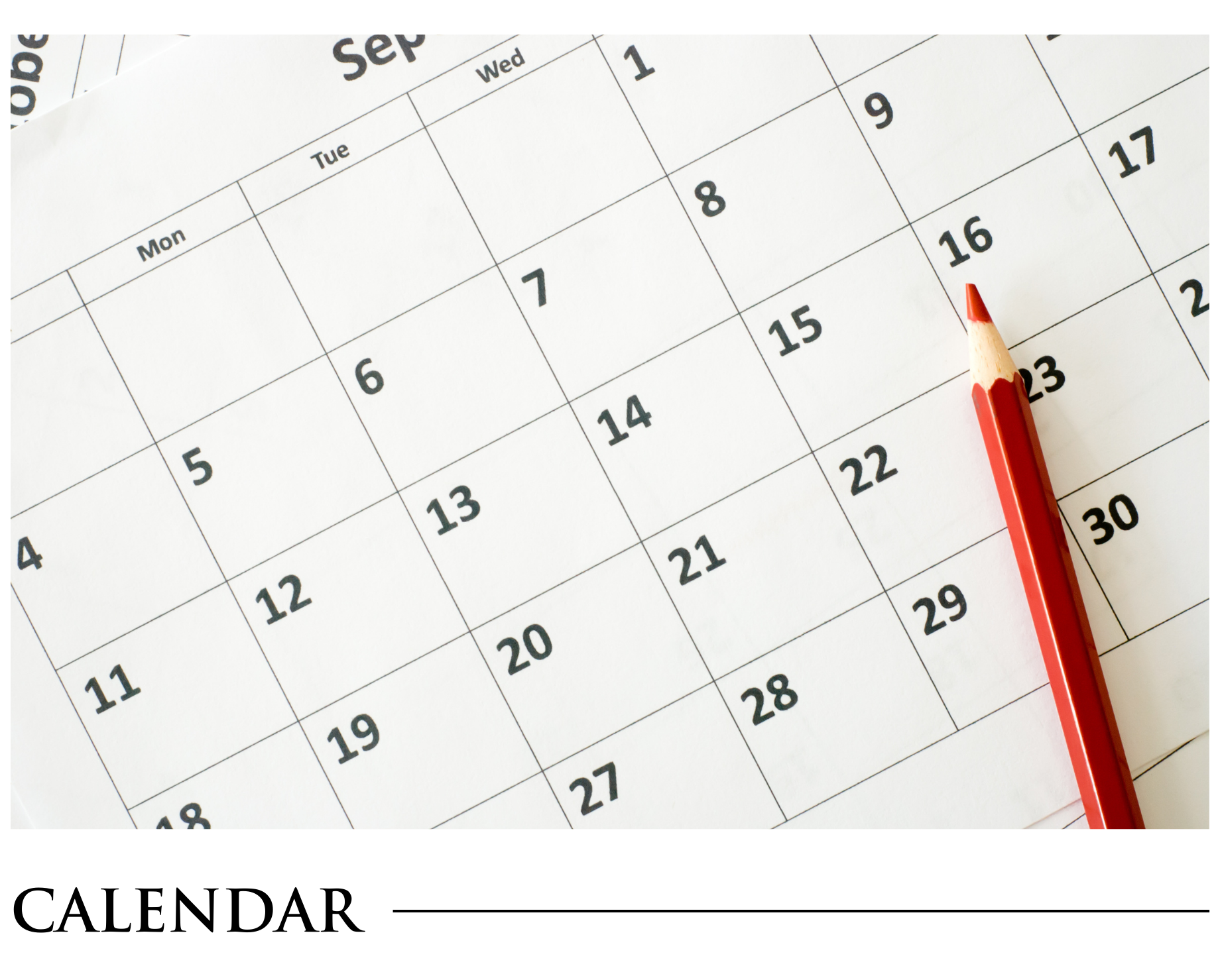 A calendar with a red pencil on top of it