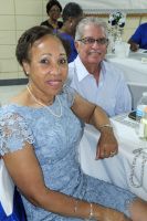 Two people seated at a decorated banquet table, smiling at the camera.