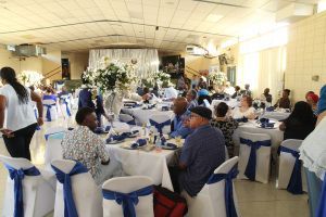Banquet hall with guests seated at decorated round tables for a formal event