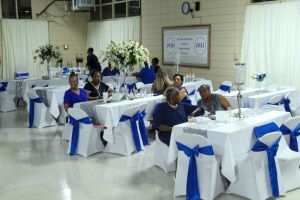 People seated at white-clothed tables with blue bows in a decorated banquet hall