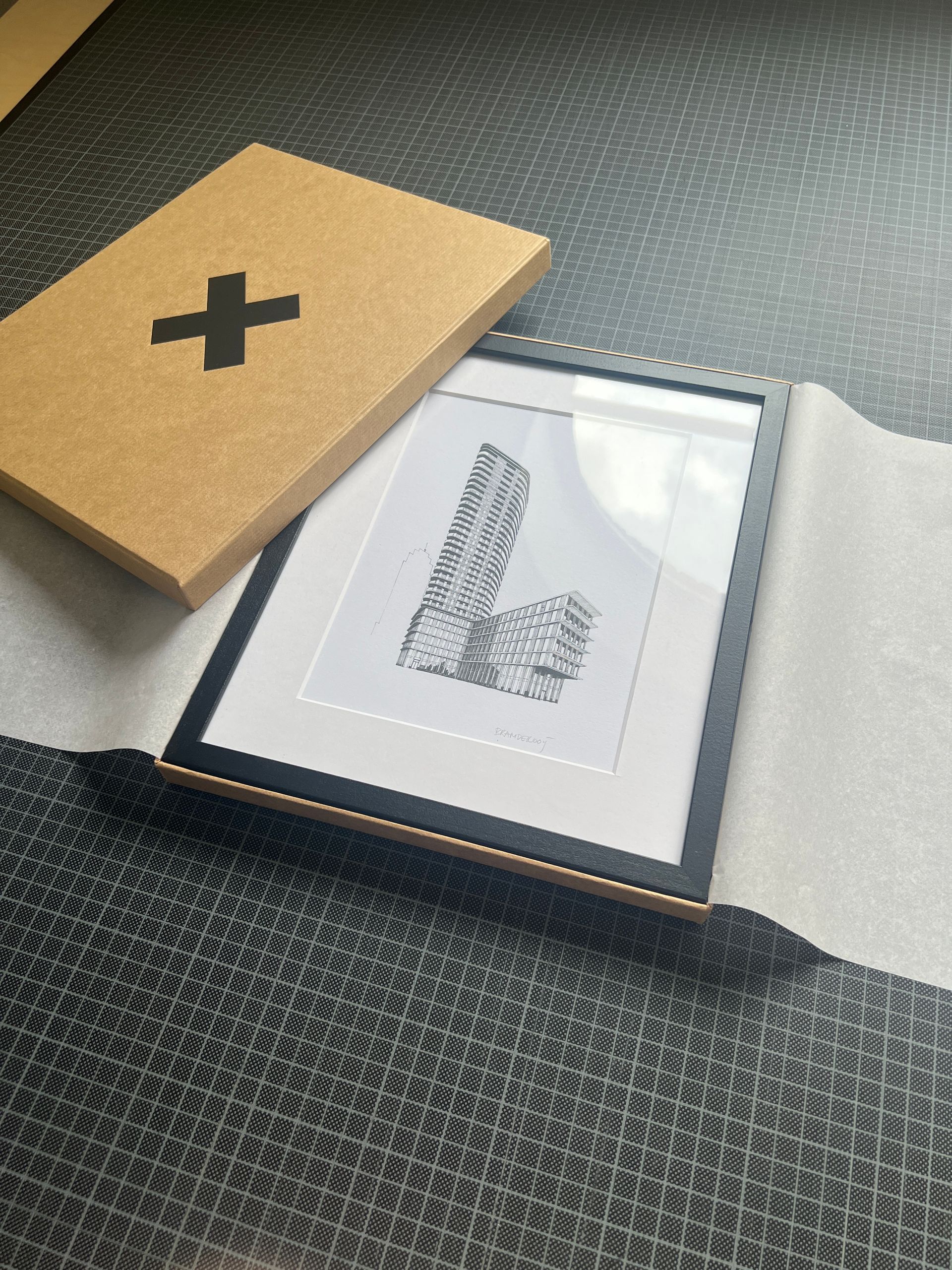 Open doos met daarin een ingelijst kunstwerk.