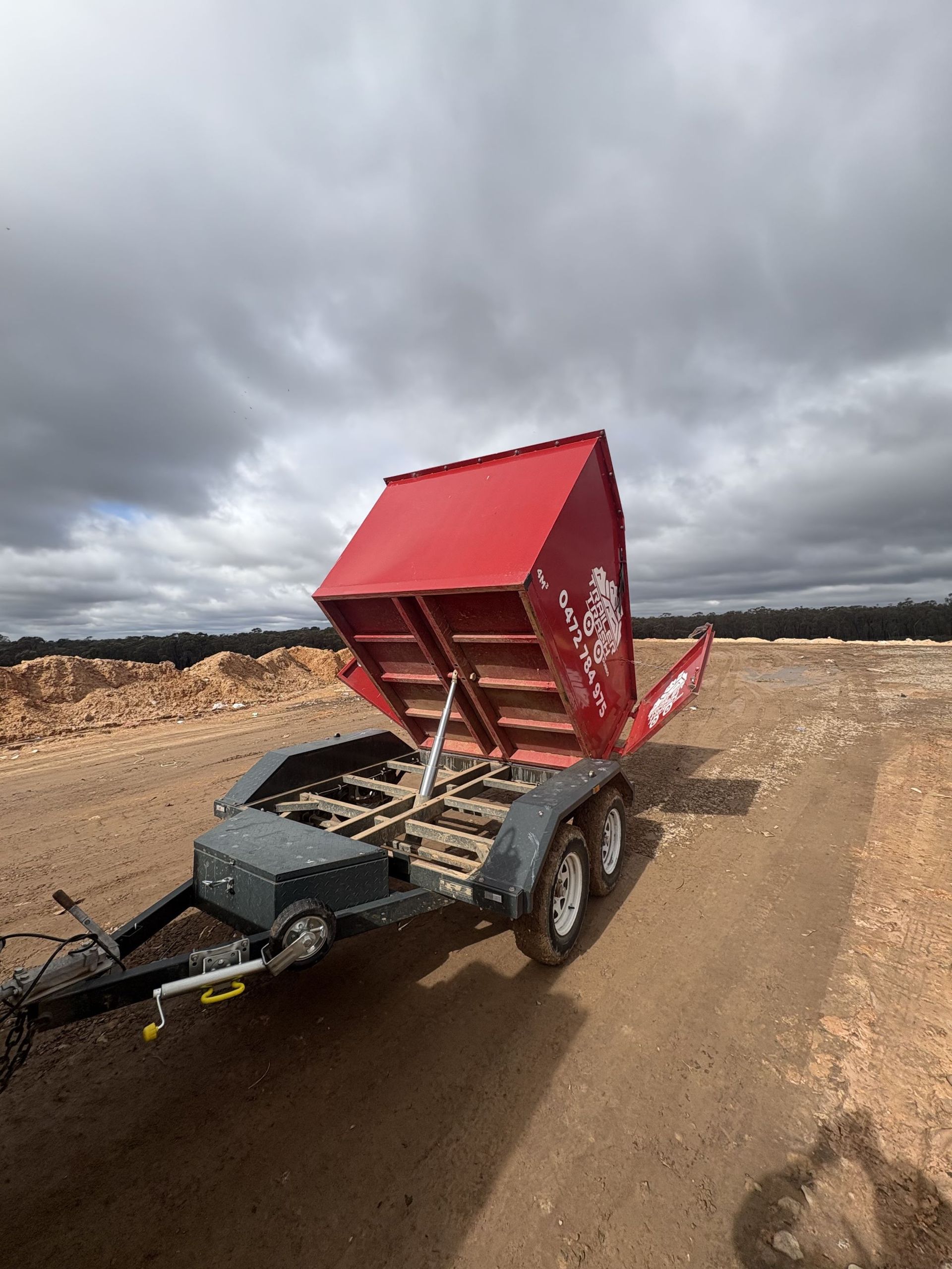 Red Dump Trailer Raised on a Dirt Road, Under a Cloudy Sky — Trailer Trash Dubbo in Wongarbon, NSW