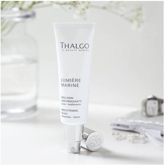 Thalgo Lumière Marine skincare tube on a white table with a jar and soft decor background