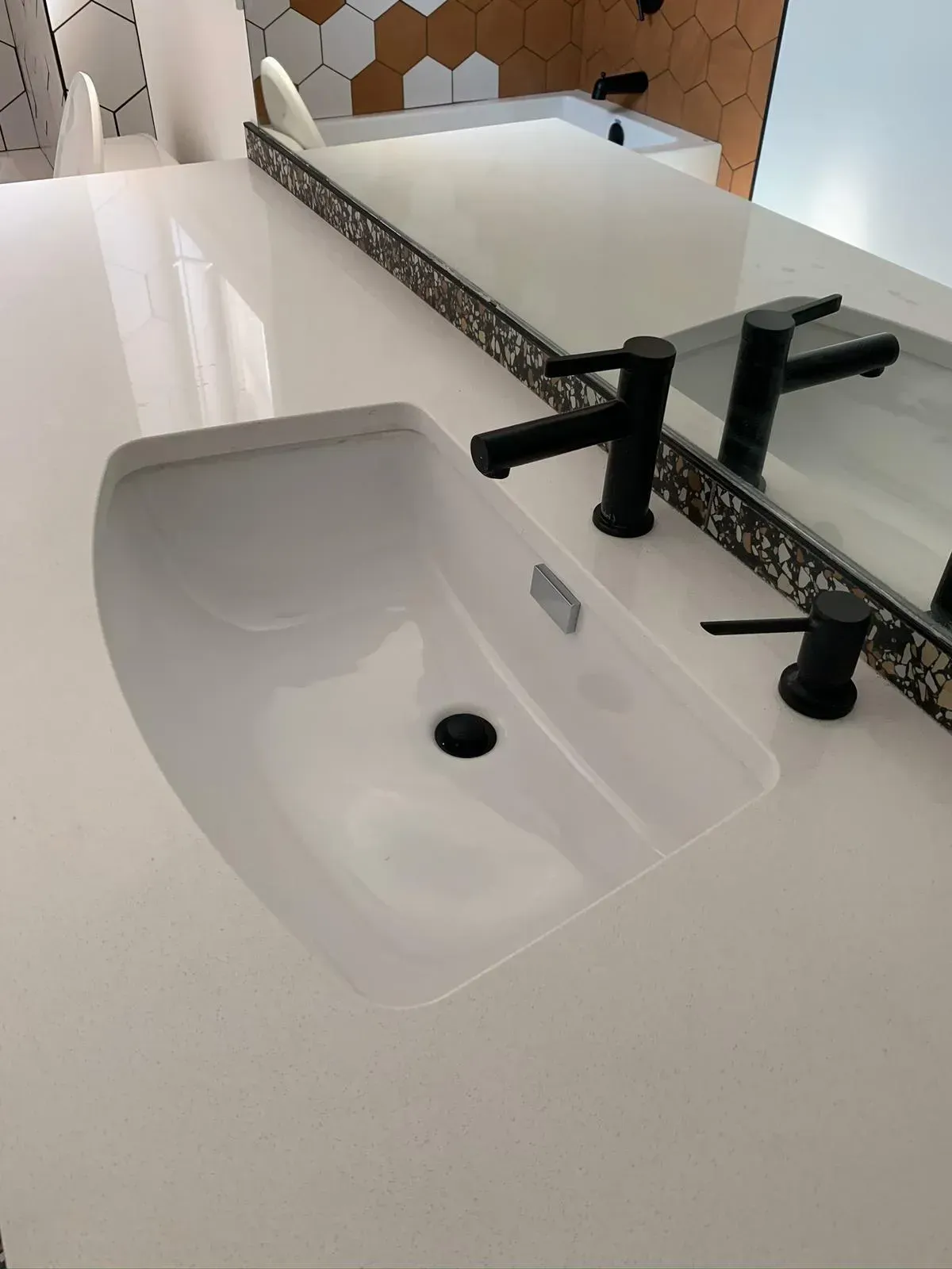 A bathroom sink with black faucets and a mirror.