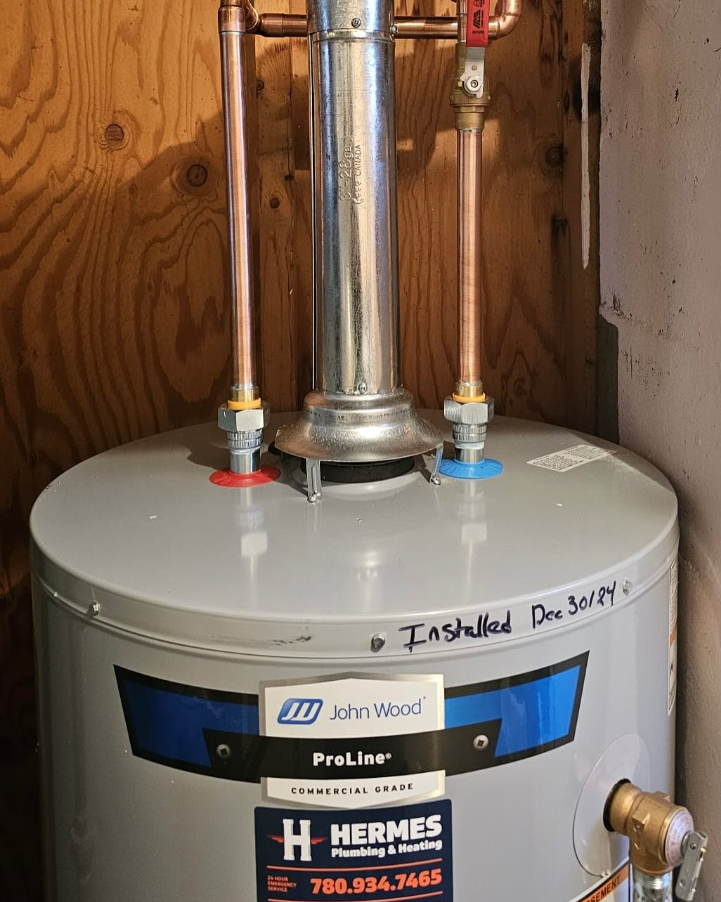Gray water heater with copper pipes and a flue against a wood-paneled wall.
