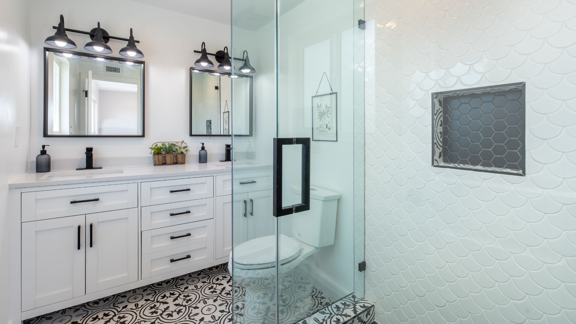 A bathroom with two sinks , a toilet , and a walk in shower.