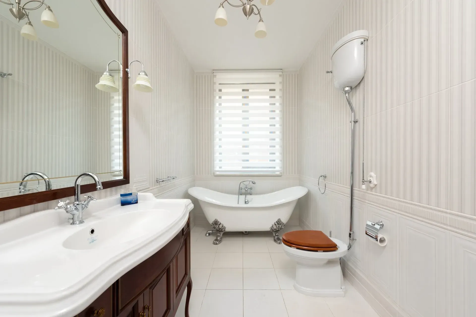 A bathroom with a tub , toilet , sink and mirror