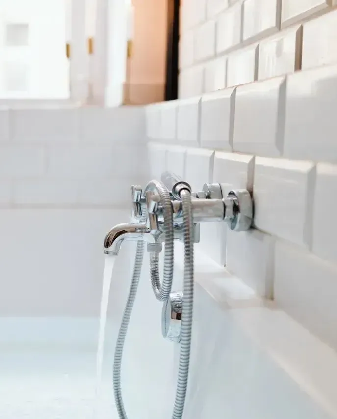 A bathtub with a shower head attached to it in a bathroom.
