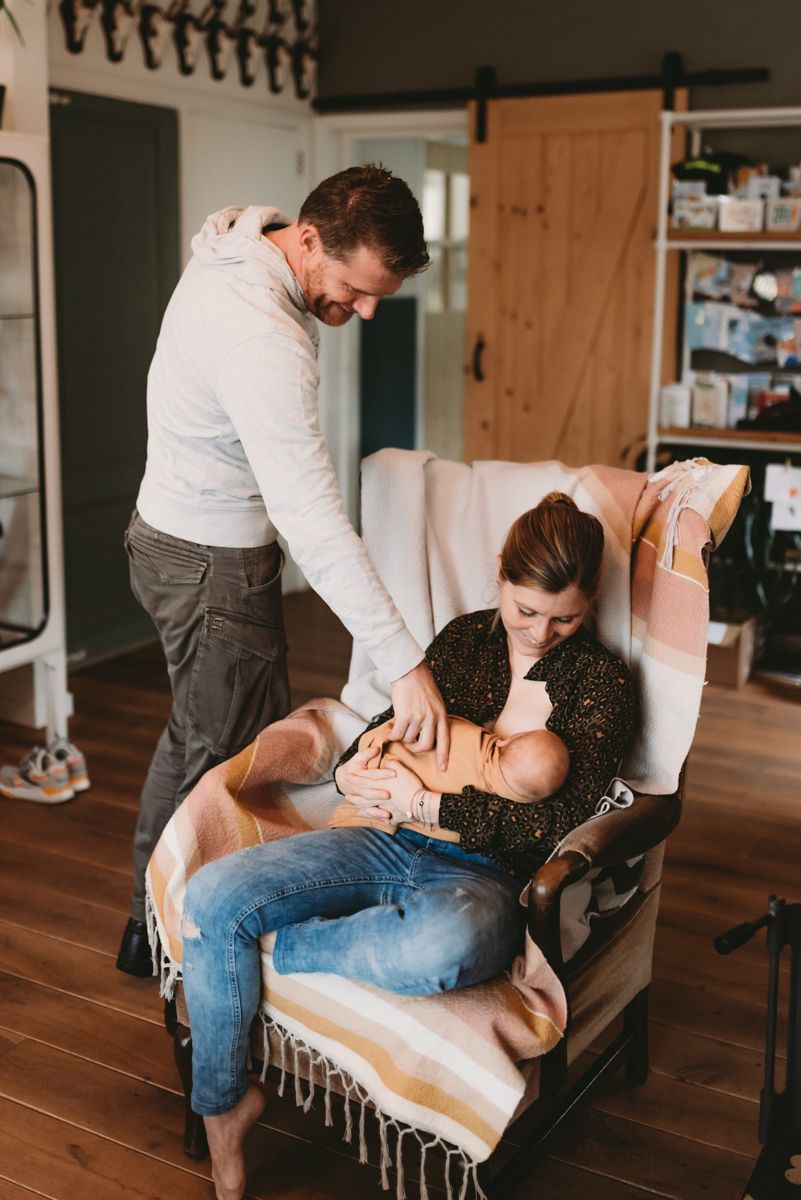 Borstvoedingsfotografie - moeder geeft borstvoeding op de stoel
