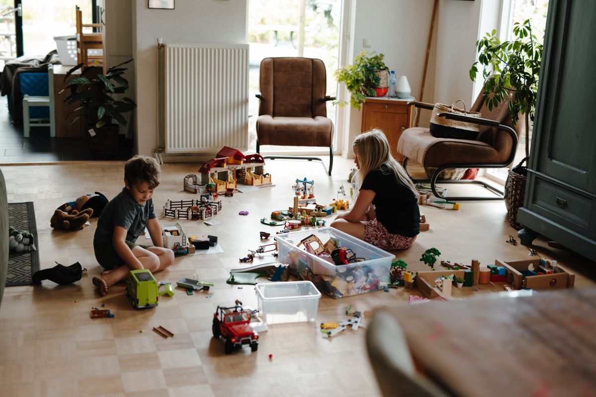 Kinderen spelen met playmobile in de huiskamer tijdens een fotoshoot
