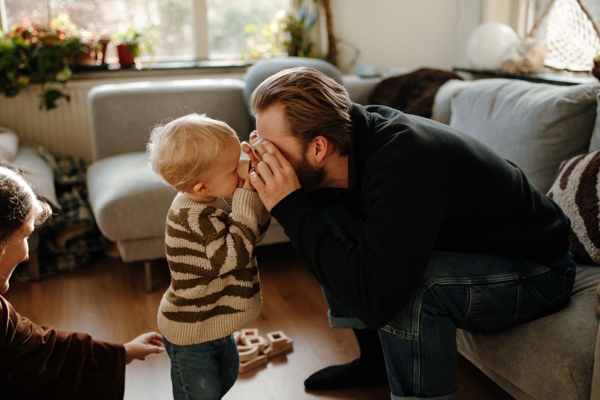 Vader en zoon spelen tijdens een fotoshoot bij hun thuis