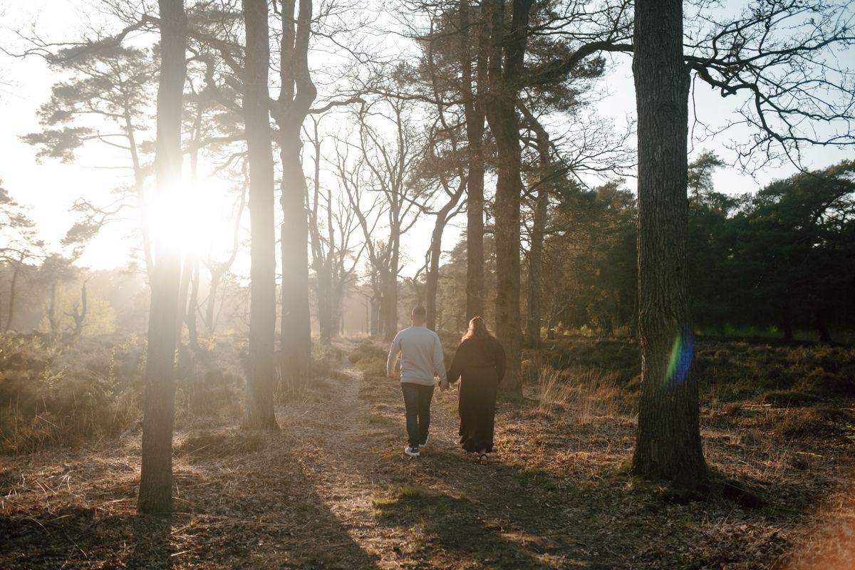 Stel wandelt door het bos tijdens een fotoshoot