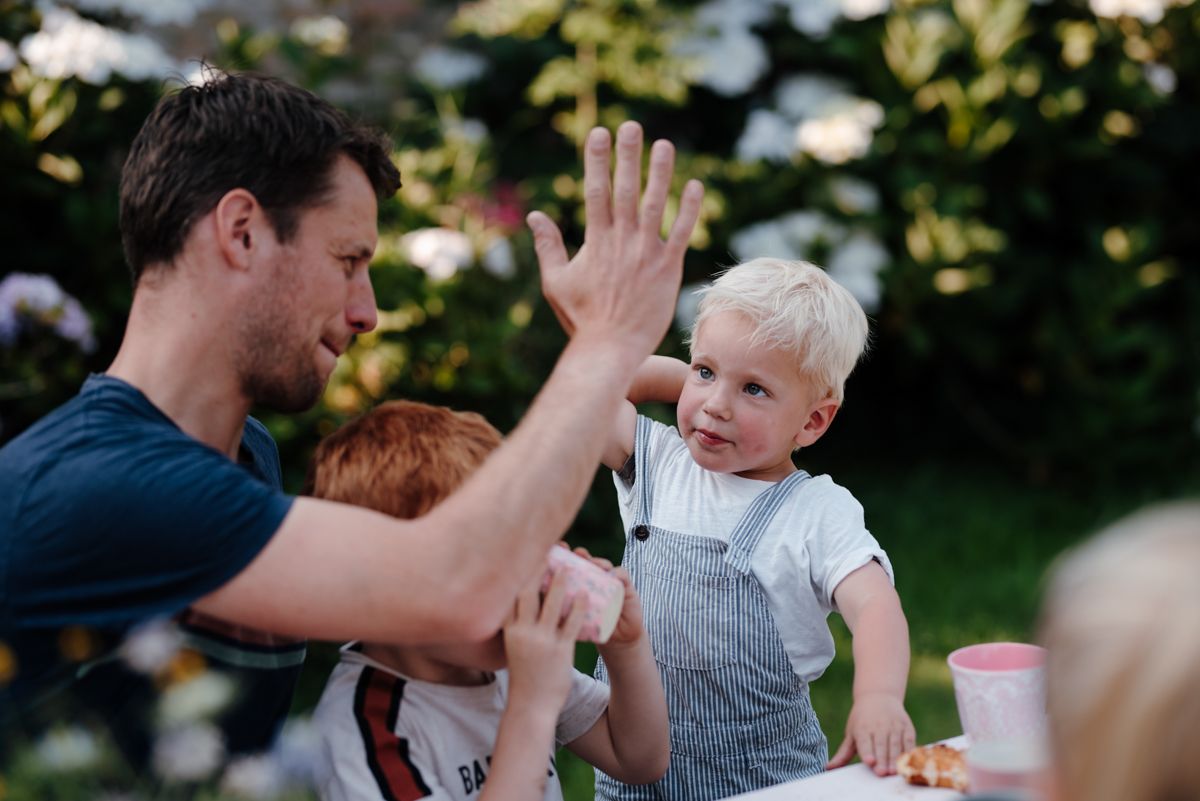 Een man en twee kinderen geven elkaar een high five