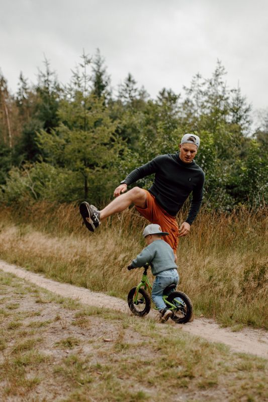 Kinderen rennen vrij door het bos tijdens een buitenfotoshoot in de natuur in Friesland