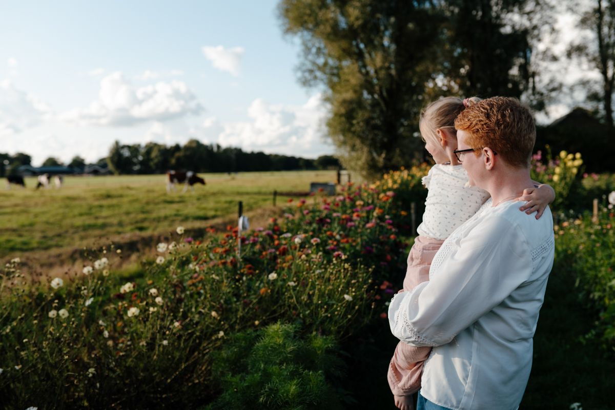 Moeder en dochter kijken over de weilanden naar de koeien in de pluktuin waar ze een fotoshoot hebben
