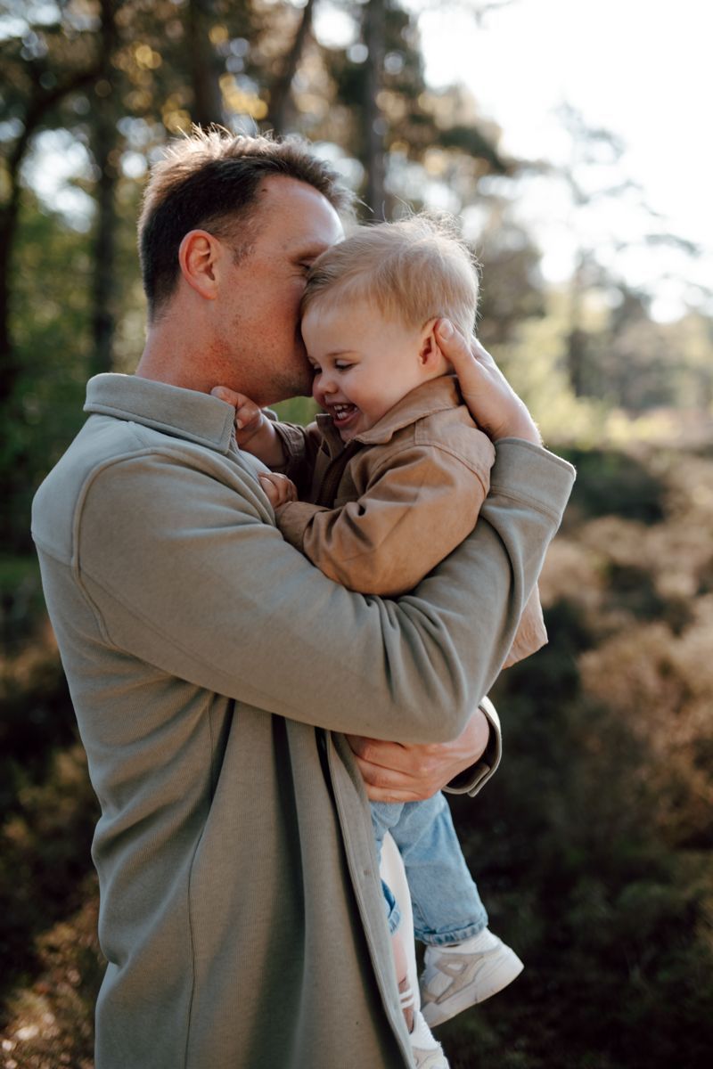 Vader en zoon samen achtend op de foto tijdens een gezinsfotoshoot