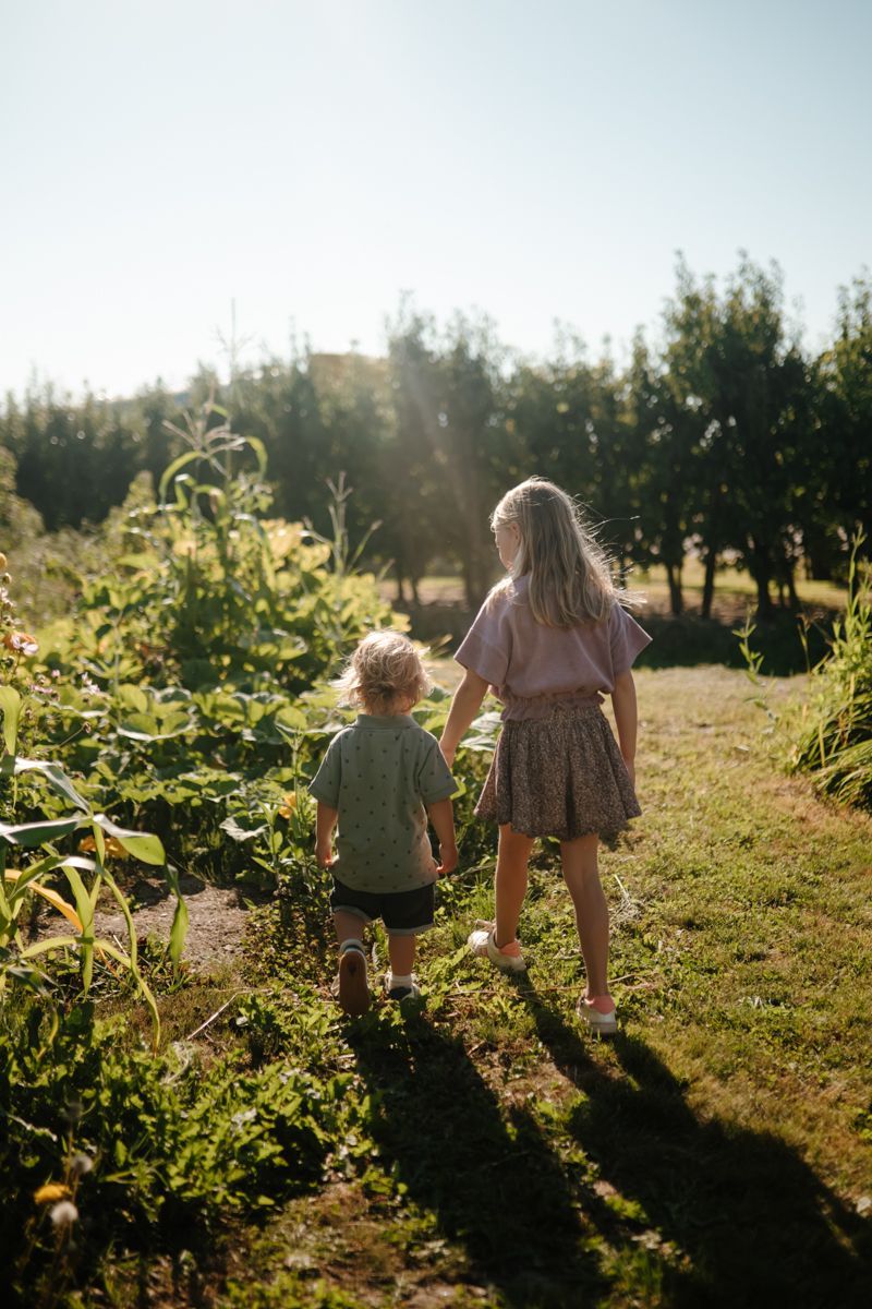 twee kinderen wandelen samen richting de moestuin