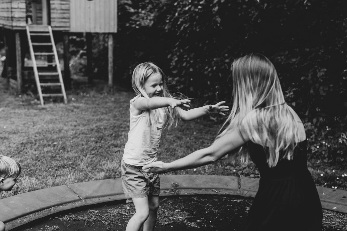 Samen met mama op de trampoline tijdens een gezinsshoot in de moestuin
