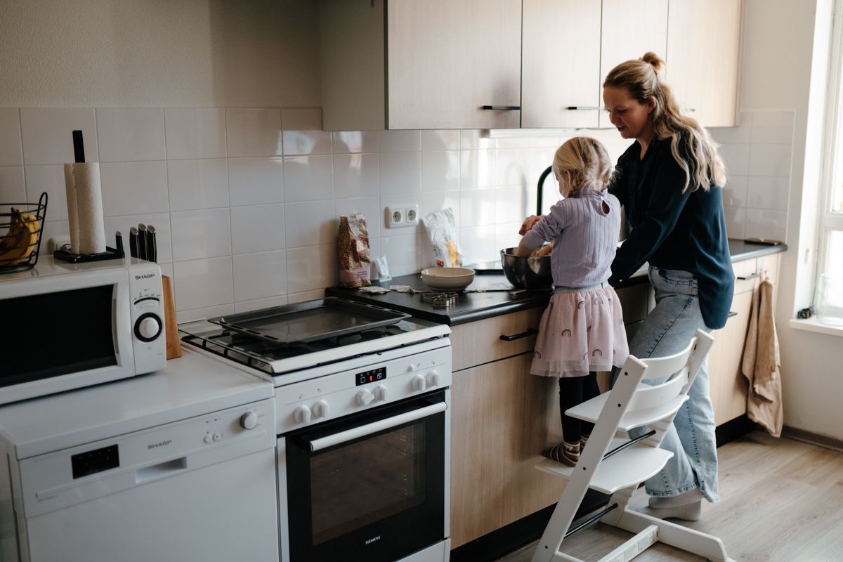 Moeder en dochter samen in de keuken, koekjes bakken tijdens een fotoshoot