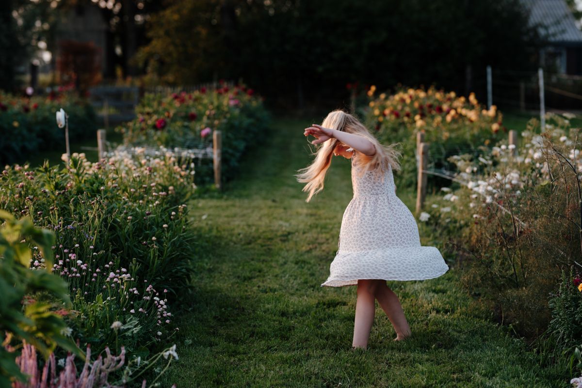 Dansend meisje tijdens een fotoshoot in de pluktuin