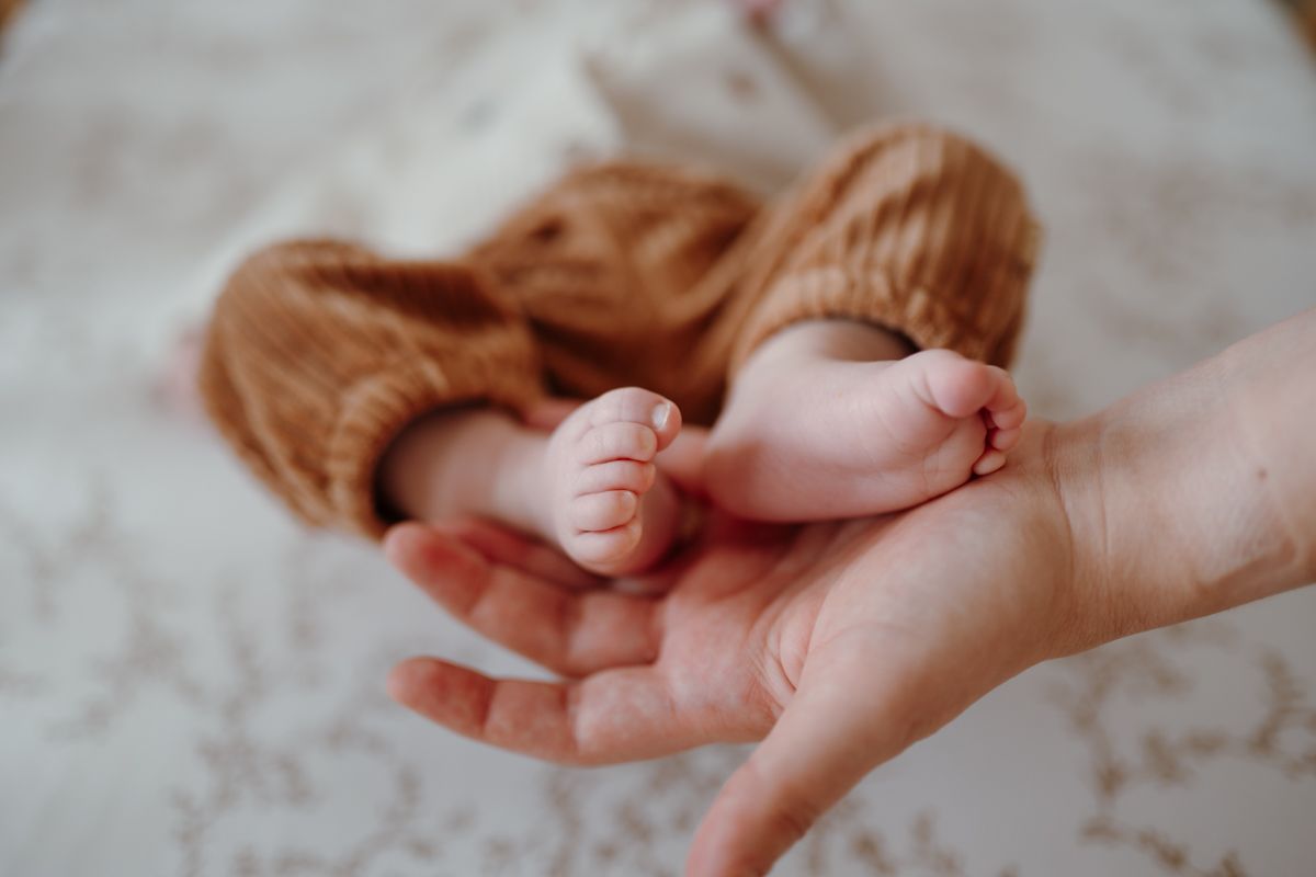 Foto van babyvoetjes in de handen van de moeder tijdens de newbornshoot in sneek
