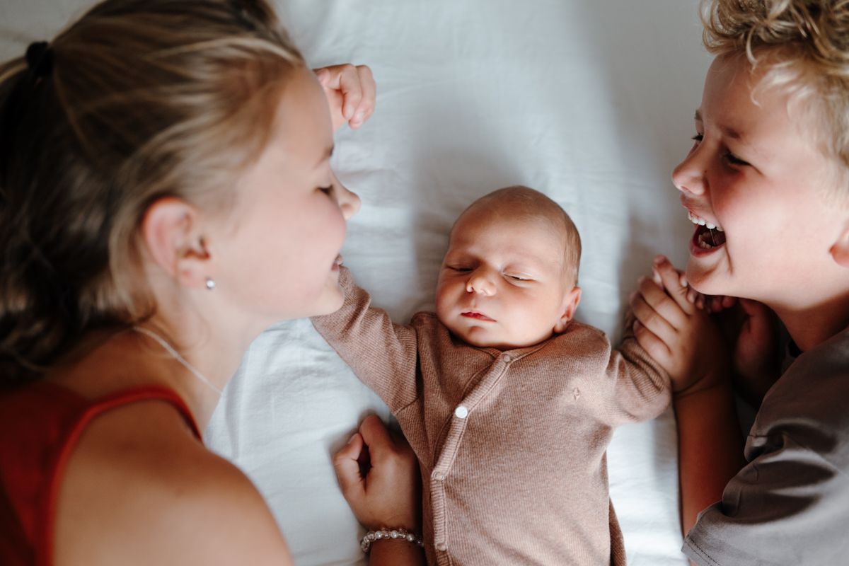 Fotograaf Drenthe Baby broertje met grotere broer en zus tijdens een newbornshoot in Drenthe