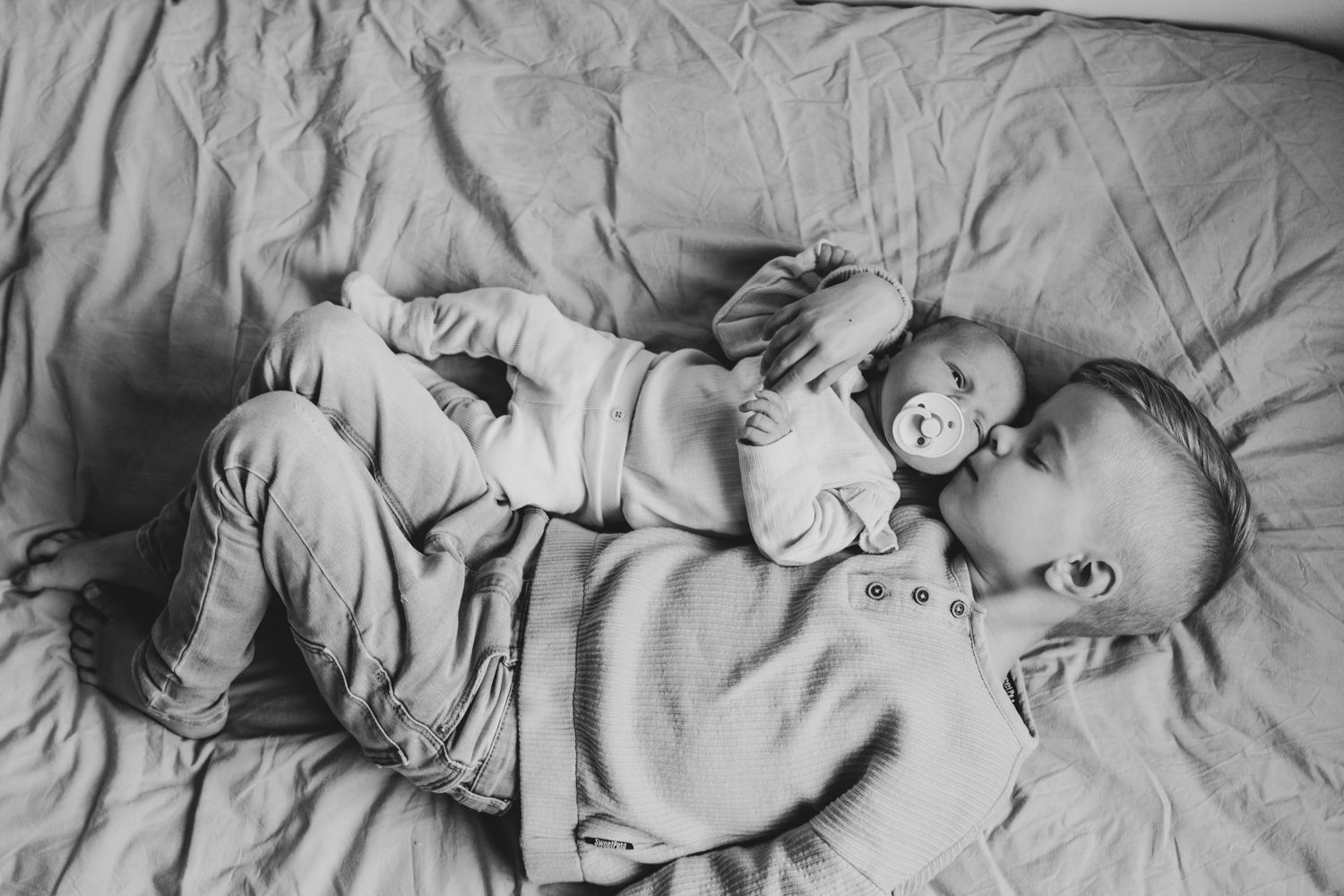 Newbornfotoshoot zwart wit foto broer en zusje
