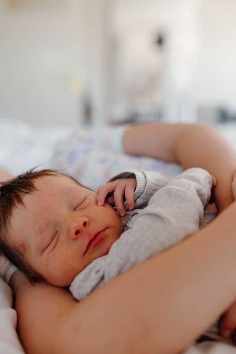 Baby slaapt in de armen van grote zus tijdens de fotoshoot