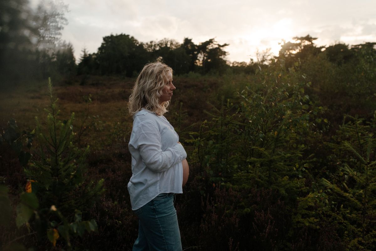 Zwangere vrouw in de heide tijdens een zwangerschapsshoot in Drenthe