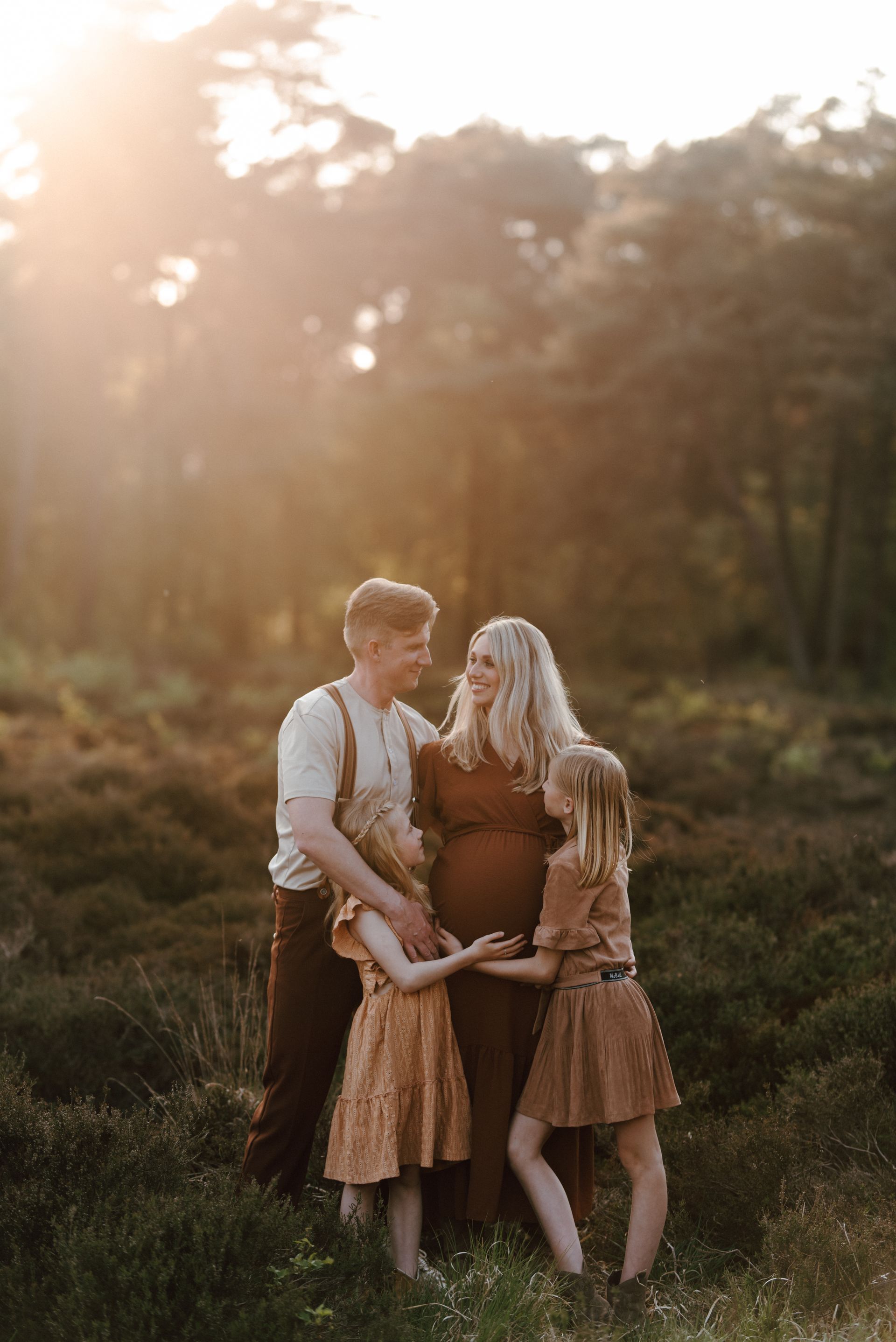 Gezin op de foto tijdens een zwangerschapsshoot in de heide