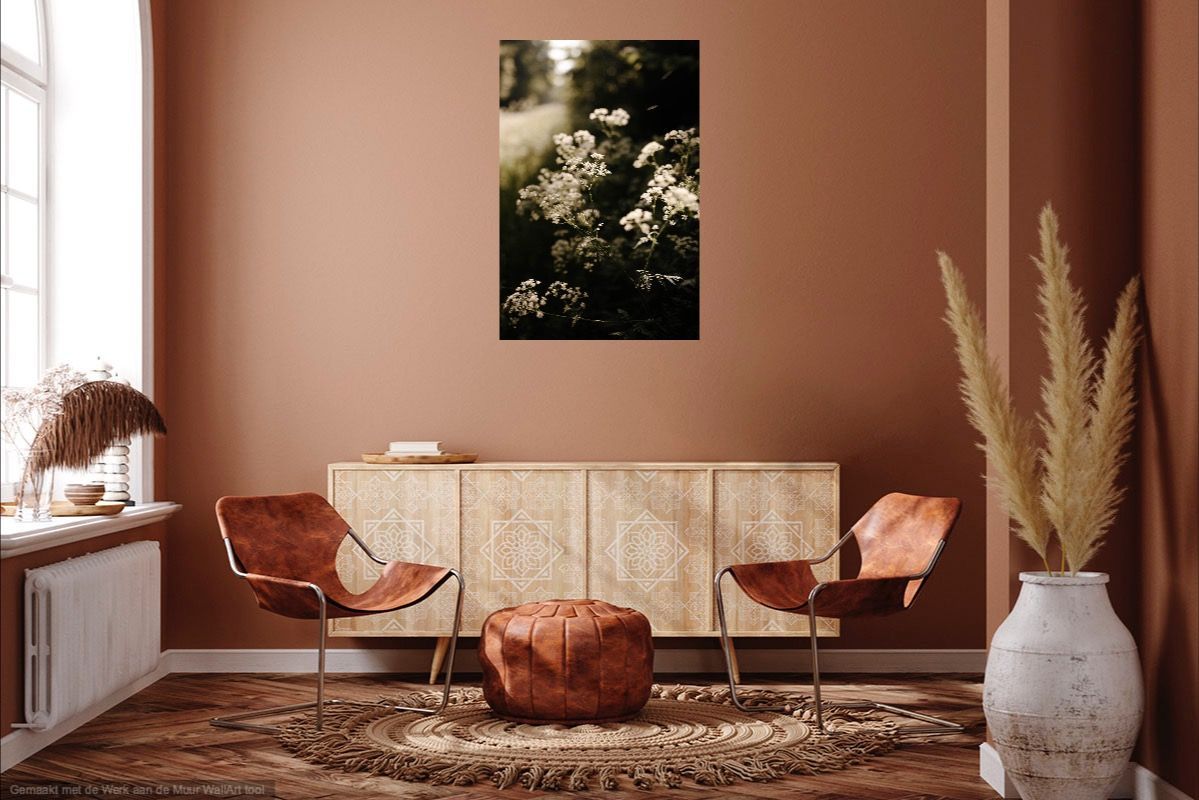 Sfeervolle woonkamer met beige stoelen, een gevlochten kast, gedroogd pampasgras en een bloemenprint aan de muur.
