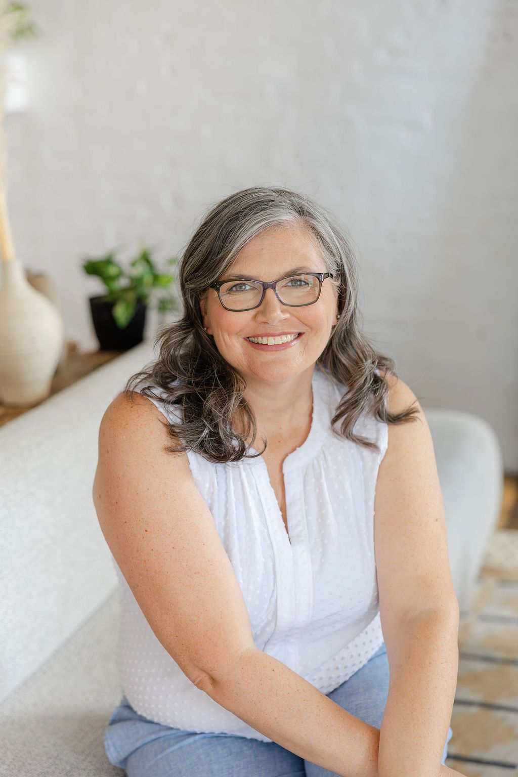 Diane of founder of Shared Suitcase Travel sitting on couch