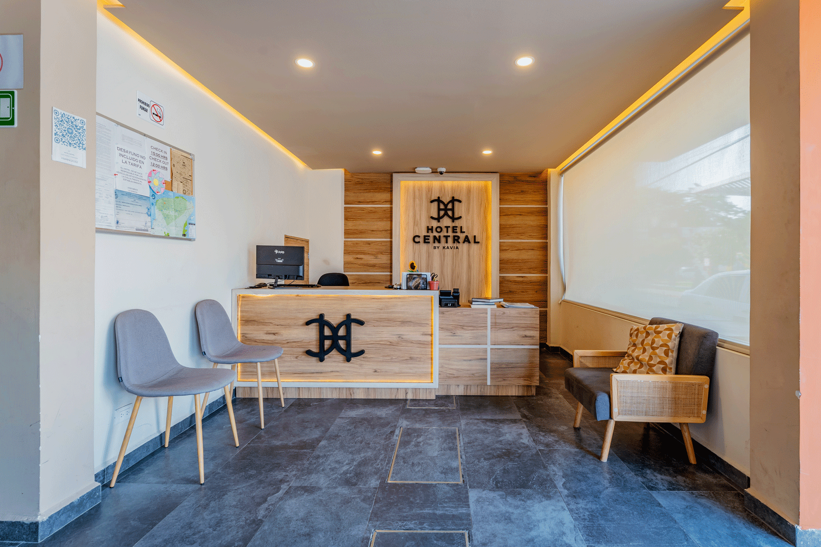 Área de recepción central del hotel con escritorio, asientos y detalles de madera.
