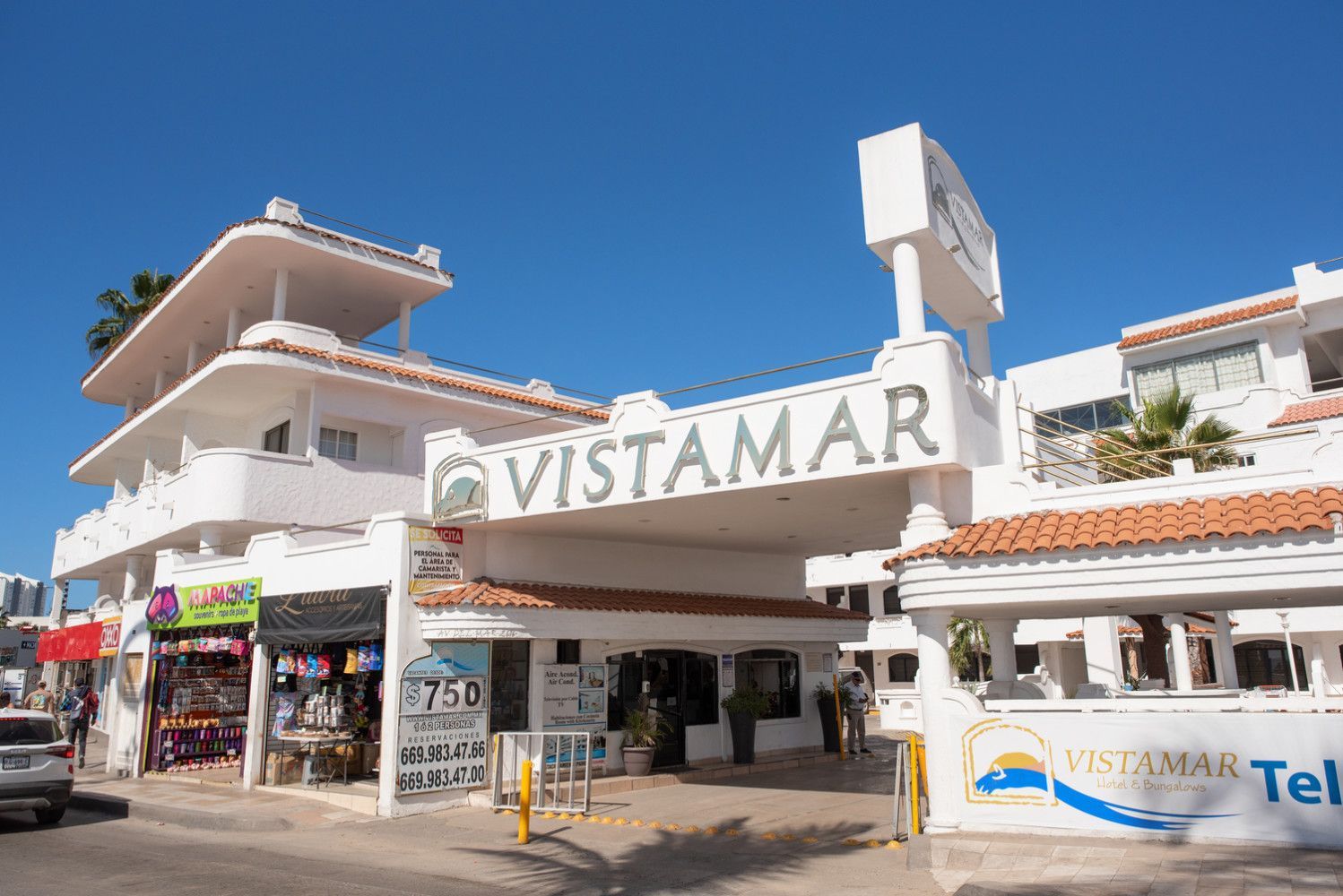 Entrada al hotel Vistamar, edificio blanco con señalización, cielo azul.
