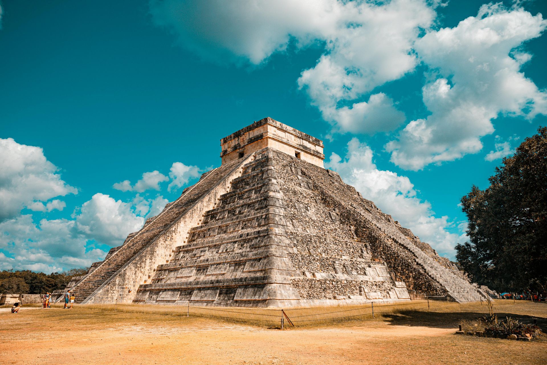 Pirámide de Chichén Itzá, antiguas ruinas mayas, contra un cielo azul con nubes blancas.